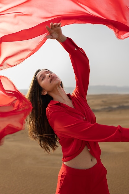 Free photo medium shot expressive woman throwing red scarf