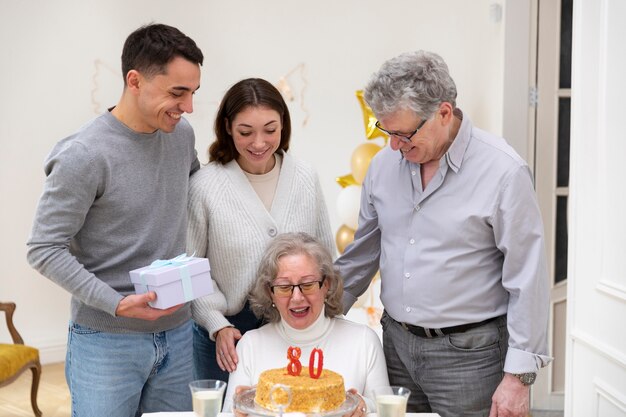 Medium shot family celebrating with cake