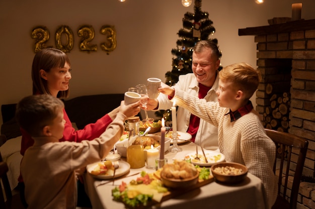 Free photo medium shot family clinking glasses