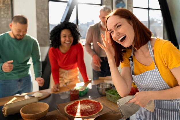 Medium shot family cooking delicious pizza