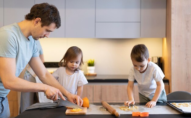 Foto gratuita famiglia del colpo medio che cucina in cucina