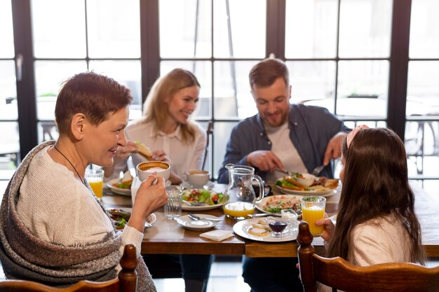 Medium shot family eating together at table