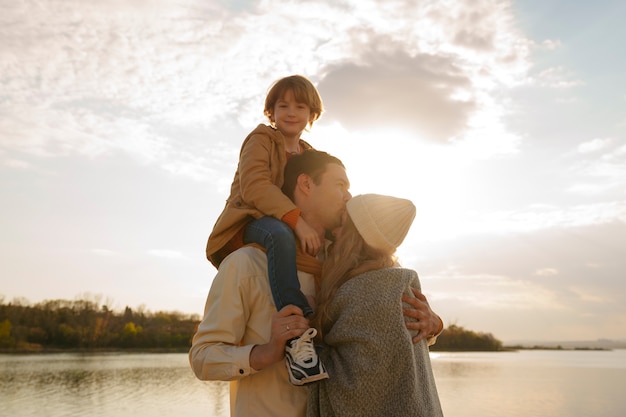 Foto gratuita famiglia del piano medio che va in giro su un molo