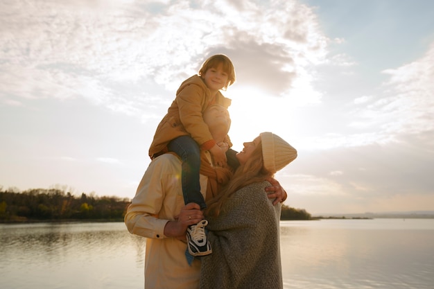 Foto gratuita famiglia del piano medio che va in giro su un molo