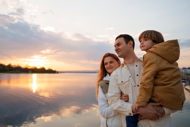 Medium shot family hanging out on a jetty