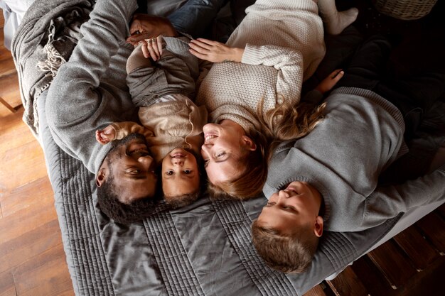 Medium shot family laying on bed