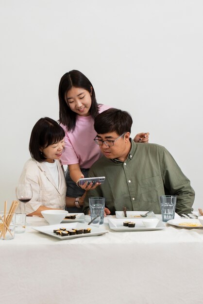 Medium shot family looking at smartphone