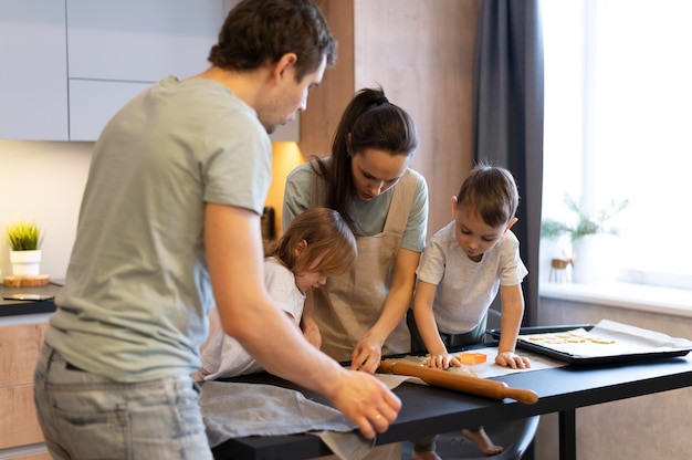 Free photo medium shot family making cookies