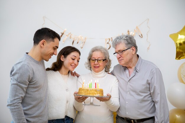 Medium shot family members holding cake