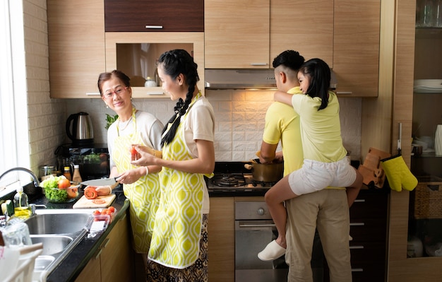 Бесплатное фото Члены семьи среднего размера на кухне