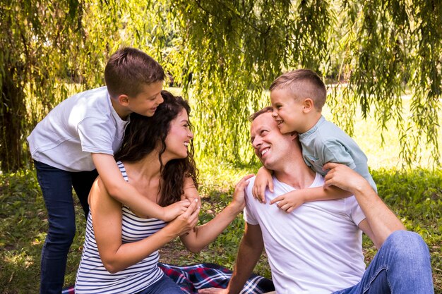 Medium shot family playing on picnic blanket