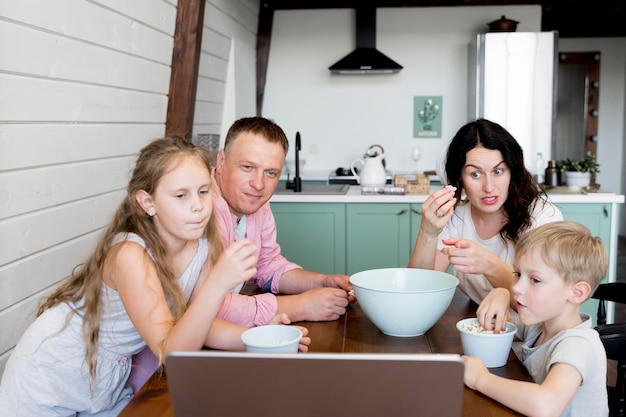 Foto gratuita famiglia di tiro medio seduto al tavolo