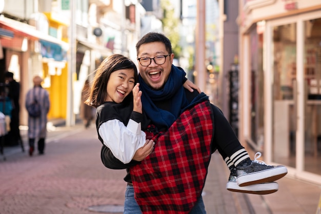 Free photo medium shot father carrying daughter