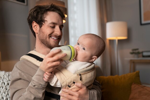 Medium shot father feeding baby