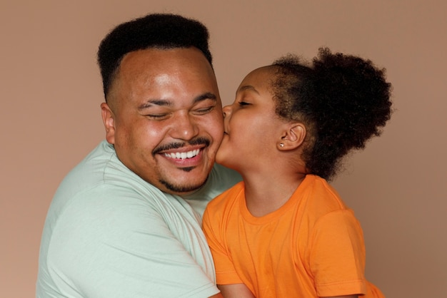 Free photo medium shot father and girl posing in studio