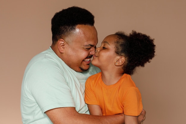 Medium shot father and girl posing in studio