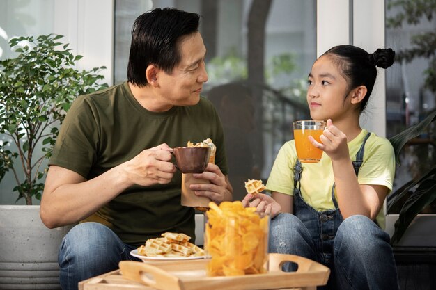 Medium shot father and girl taking lunch break