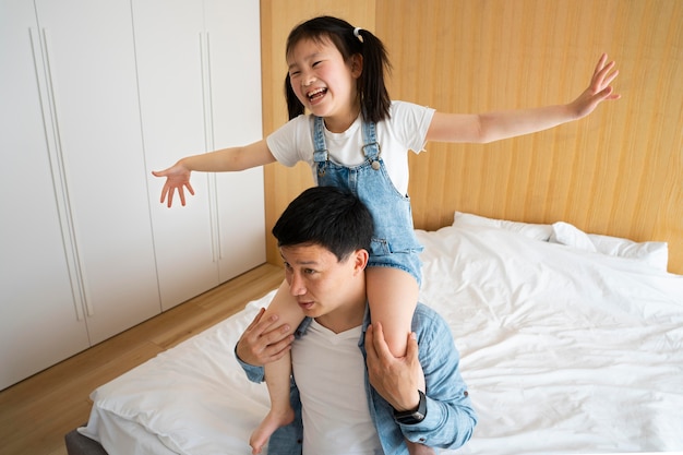 Free photo medium shot father holding girl on shoulders