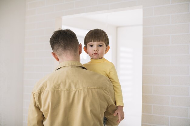 Medium shot of father holding his son