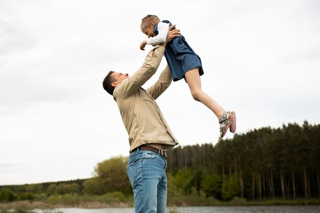 Medium shot father holding kid up