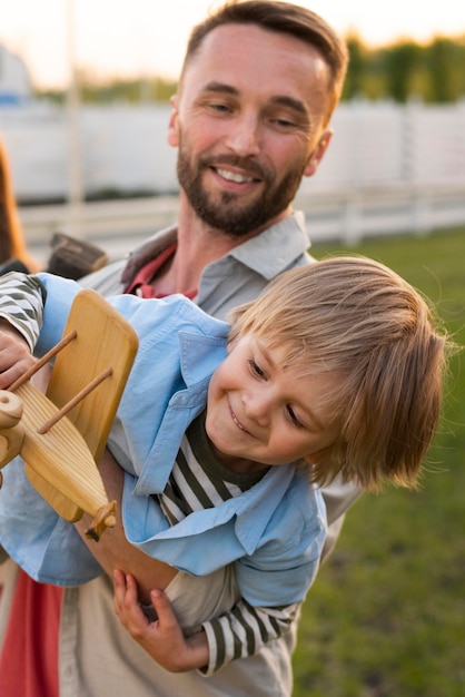 Padre a tiro medio che tiene in braccio un bambino