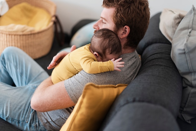 Средний выстрел отца обнимает ребенка на диване