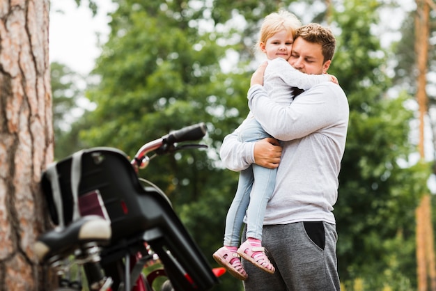 Medium shot father hugging daughter