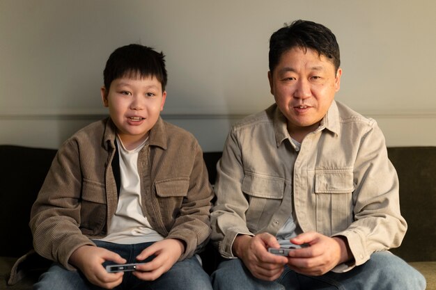 Medium shot father and kid playing videogame