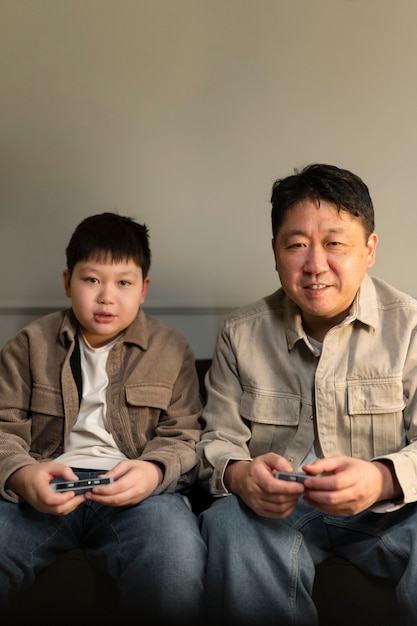 Foto gratuita padre e figlio di tiro medio che giocano al videogioco