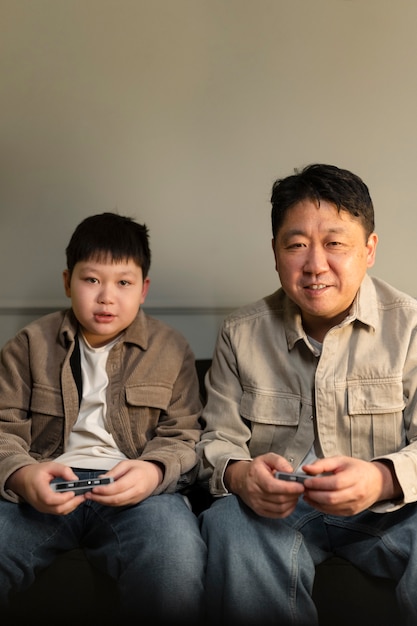Medium shot father and kid playing videogame