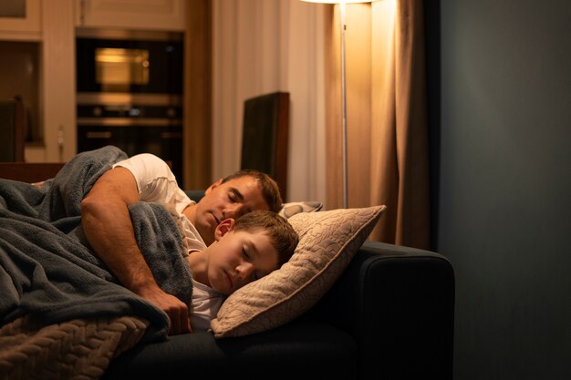 Medium shot father and kid sleeping on couch