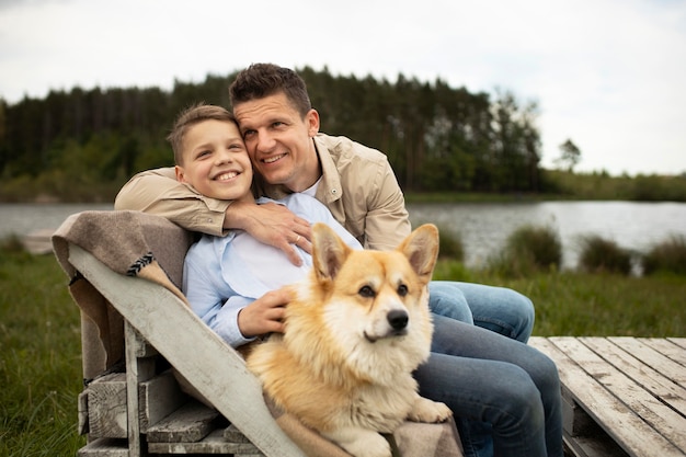 ミディアムショットの父と犬と子供