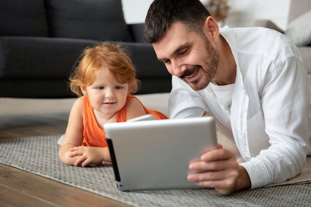 Средний снимок отца и ребенка с планшетом