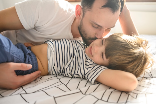 medium shot father kissing son