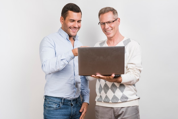 Medium shot of father and son with laptop