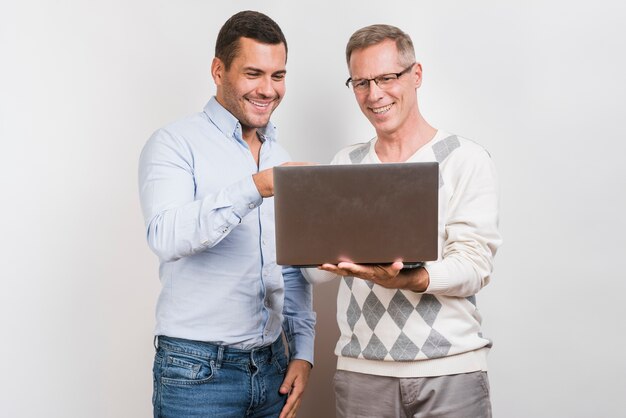 Средний снимок отца и сына с ноутбуком