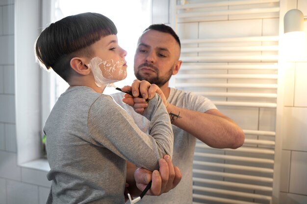 Medium shot father teaching kid how to shave