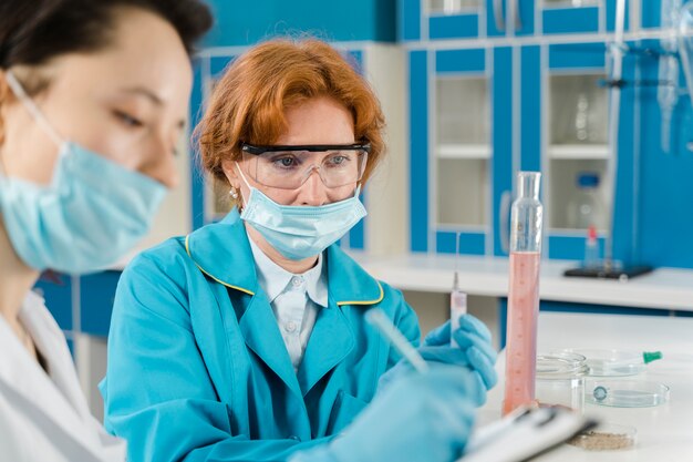 Medium shot of female chemists wearing masks