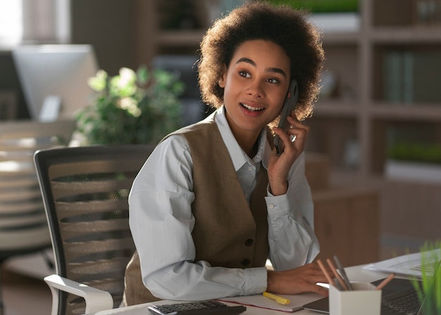 Medium shot female economist holding smartphone