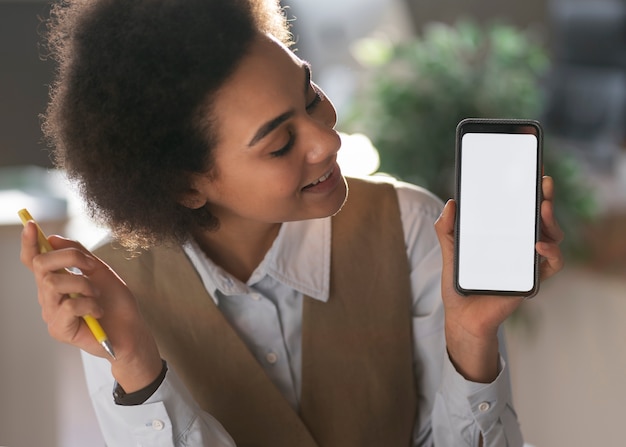 Economista femminile del colpo medio che tiene smartphone