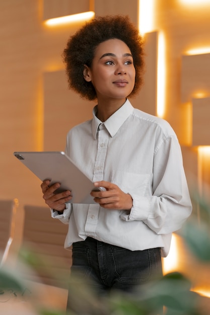 Free photo medium shot female economist holding tablet