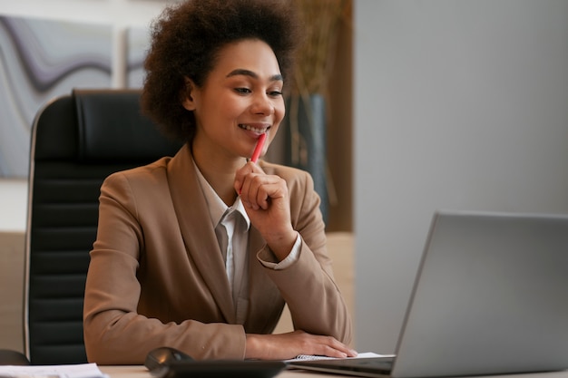 Medium shot female economist working on laptop