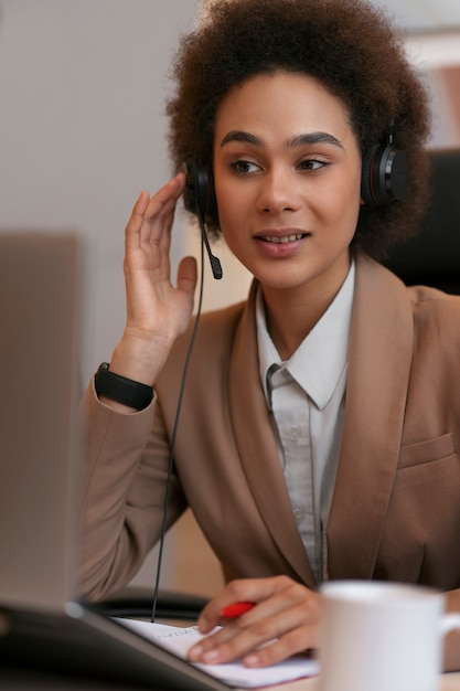 Economista femminile del colpo medio che lavora al computer portatile