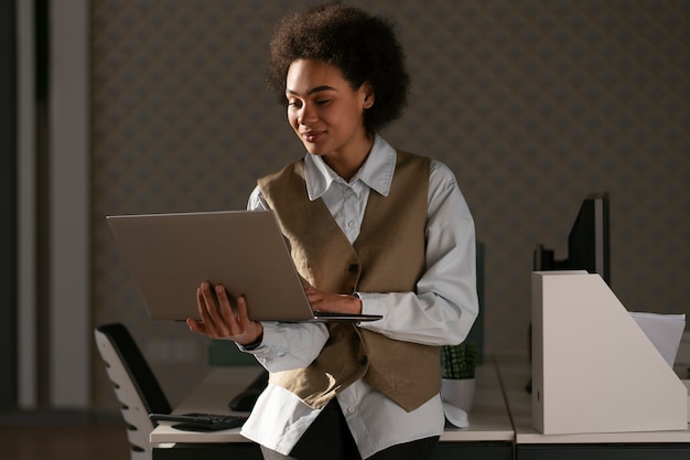 Medium shot female economist working on laptop