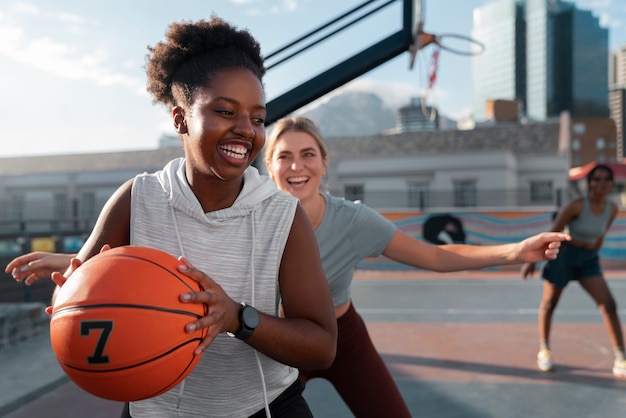 medium shot female friends playing basketball
