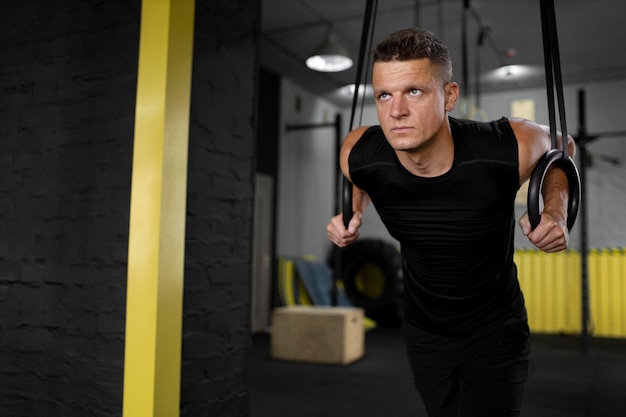 Foto gratuita uomo in forma di tiro medio che si allena in palestra