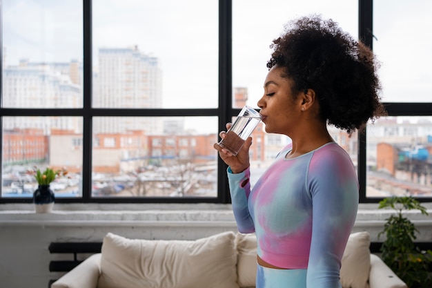 Foto gratuita acqua potabile della donna adatta del colpo medio