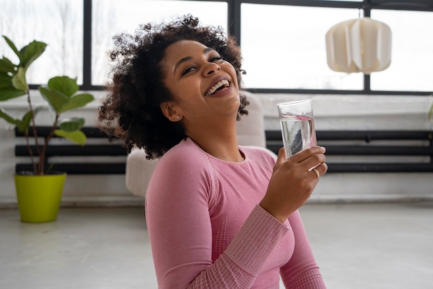 Medium shot fit woman drinking water