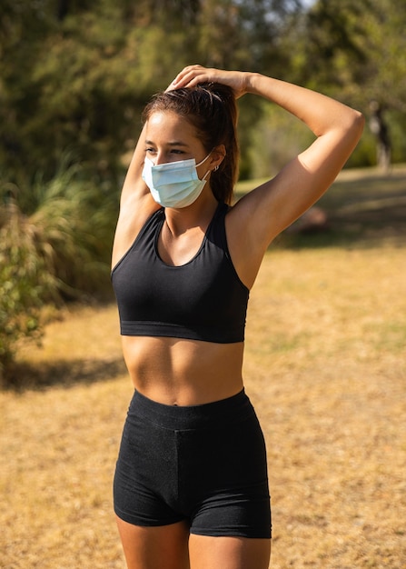 Foto gratuita maschera da portare della donna adatta del colpo medio