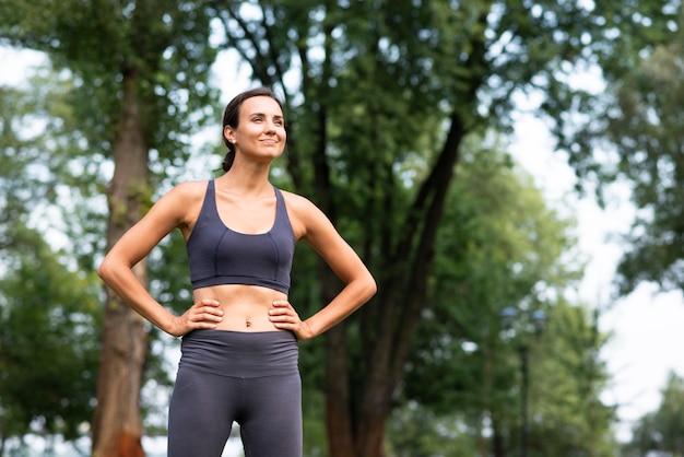 Colpo medio donna in forma con le mani sui fianchi